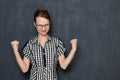 Portrait of satisfied girl showing hooray gesture with fists