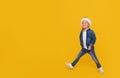 Portrait of a satisfied little child boy dressed in christmas Santa hat. laughing isolated over colored yellow background. Royalty Free Stock Photo