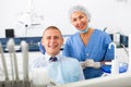 Portrait of satisfied man visiting dentist giving thumbs up in the dental clinic Royalty Free Stock Photo