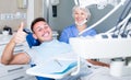 Portrait of satisfied man visiting dentist giving thumbs up Royalty Free Stock Photo