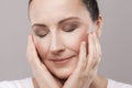 Portrait of satisfied middle aged woman with perfect face skin relaxation after spa procedure with closed eyes isolated on grey Royalty Free Stock Photo