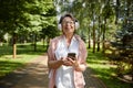 Portrait of satisfied old woman using mobile enjoying summer in park Royalty Free Stock Photo