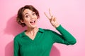 Portrait of satisfied optimistic girlish woman with short hair wear stylish shirt showing v-sign symbol isolated on pink Royalty Free Stock Photo