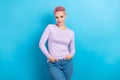 Portrait of satisfied pleasant nice looking girl with short hairdo dressed pink shirt arms in pockets isolated on blue Royalty Free Stock Photo