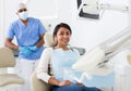 Portrait of satisfied woman visiting dentist giving thumbs up in dental clinic Royalty Free Stock Photo