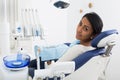 Portrait of satisfied woman visiting dentist giving thumbs up in dental clinic Royalty Free Stock Photo