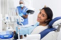 Portrait of satisfied woman visiting dentist giving thumbs up in dental clinic Royalty Free Stock Photo