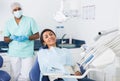 Portrait of satisfied woman visiting dentist giving thumbs up in dental clinic Royalty Free Stock Photo