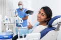 Portrait of satisfied woman visiting dentist giving thumbs up in dental clinic Royalty Free Stock Photo
