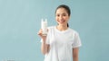 Portrait of a satisfied young asian woman drinking milk from the glass isolated over blue background Royalty Free Stock Photo