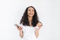 Portrait of a satisfied young woman using mobile phone while holding cup of coffee to go over white background Royalty Free Stock Photo