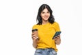 Portrait of a satisfied young woman using mobile phone while holding cup of coffee to go isolated over white background Royalty Free Stock Photo