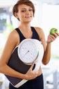Portrait, scale and happy woman with apple for diet, nutrition or wellness with healthy body. Weight loss, smile and Royalty Free Stock Photo
