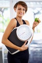 Portrait, scale and happy woman eating apple for diet, nutrition or wellness with healthy body after exercise. Weight Royalty Free Stock Photo