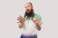 Portrait of scared middle aged bald man with long beard in light green t-shirt standing with afraid face and looking at camera