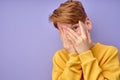 Portrait of scared teen boy, isolated on purple background. Frightened child looking at camera