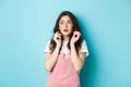 Portrait of scared timid girl in summer clothes, looking frightened at copy space banner, jumping from something scary