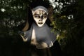 Portrait of scary devilish nun near tree outdoors. Halloween party look