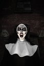 Portrait of scary devilish nun outdoors. Halloween party look Royalty Free Stock Photo