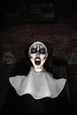 Portrait of scary devilish nun outdoors. Halloween party look