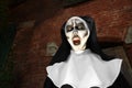 Portrait of scary devilish nun outdoors, space for text. Halloween party look