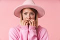 Portrait of scary woman wearing hat frightening and biting her nails