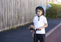 Portrait school boy ride a scooter to school, Child wearing safety helmet riding a roller, Kid standing with teddy bear looking Royalty Free Stock Photo