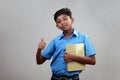 A school boy wearing uniform holds note books in hand Royalty Free Stock Photo