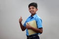 A school boy wearing uniform holds note books in hand Royalty Free Stock Photo