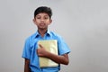 A school boy wearing uniform holds note books in hand Royalty Free Stock Photo