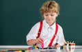 Portrait school kid boy doing art homework, holding pencil, writing. Child boy drawing on elementary school. Kids art Royalty Free Stock Photo