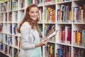 Portrait of school teacher holding book in library Royalty Free Stock Photo