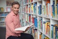 Portrait of school teacher holding book in library Royalty Free Stock Photo