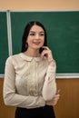 portrait of school teacher wear white blouse and glasses near on the background of the blackboard Royalty Free Stock Photo