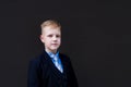 Portrait of a schoolboy against a black wall