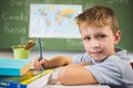 Portrait of schoolboy doing homework in classroom Royalty Free Stock Photo