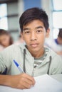 Portrait of schoolboy doing homework in classroom Royalty Free Stock Photo