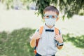 Portrait of schoolboy in glasses and butterfly wearing medicine mask