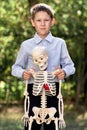 Portrait of a schoolboy hugging a skeleton. The concept of studying the structure of the body.