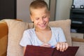 Portrait of schoolboy sitting on sofa doing homework, happy child, boy holding Royalty Free Stock Photo