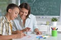 Portrait of schoolboy and teacher sitting at classroom Royalty Free Stock Photo