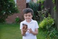 Portrait schoolboy using smartphone typing text messages,Happy kid standing outdoor using cellphone talking with friends,Child boy