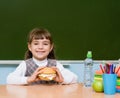 Portrait schoolgirl looking at camera while having lunch during Royalty Free Stock Photo