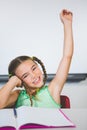 Portrait of schoolgirl raising her hand in classroom Royalty Free Stock Photo