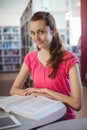 Portrait of schoolgirl reading book in library Royalty Free Stock Photo