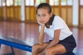 Portrait of schoolgirl sitting in basketball court