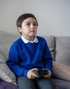 Portrait schoolkid holding video game or game console. Child playing game online at home after back from school, A boy relaxing at