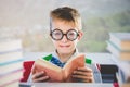 Portrait of schoolkid reading book in classroom