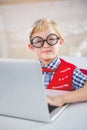 Portrait of schoolkid using laptop in classroom