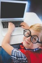 Portrait of schoolkid using laptop in classroom